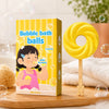 Bombe de bain sucette jaune mangue avec packaging et ambiance salle de bain